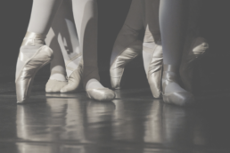 Greyed out close up shot of ballerinas wearing pointe shoes