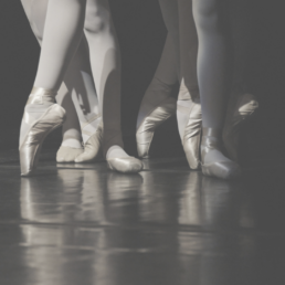 Greyed out close up shot of ballerinas wearing pointe shoes